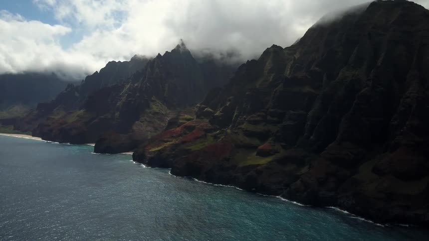 A body of water near cloudy mountains