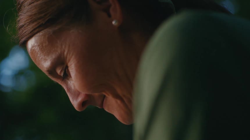 An intimate and peaceful close-up of a woman's face in profile against a soft, natural background