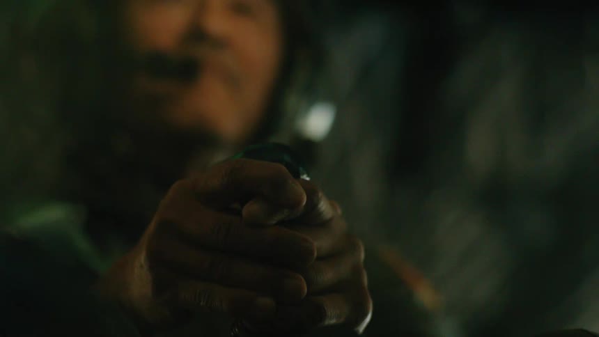A pilot's hands firmly grip the controls in a dark helicopter cockpit