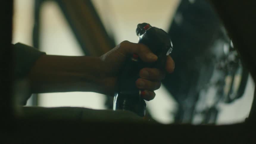 A pilot's hand firmly grips and maneuvers the joystick inside the dim, tense cockpit of an aircraft