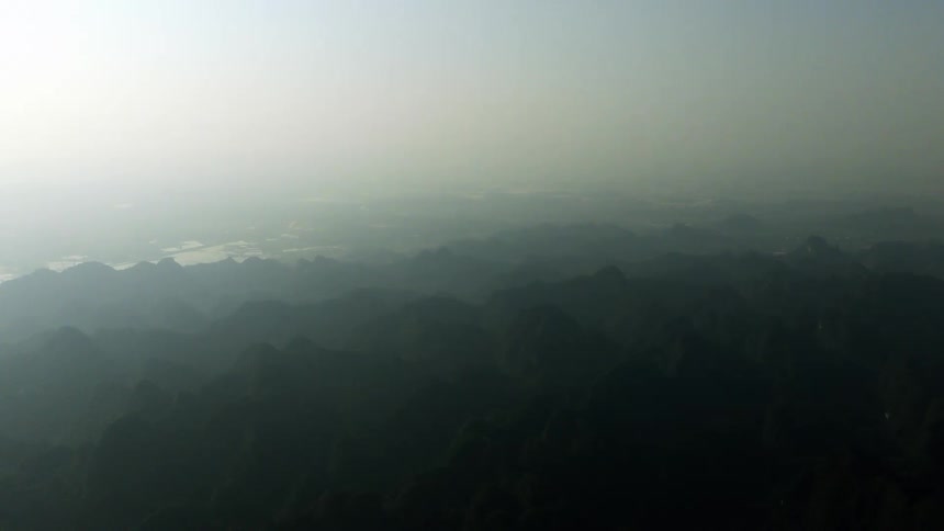 Serene aerial view of a vast mountain range shrouded in dense morning haze