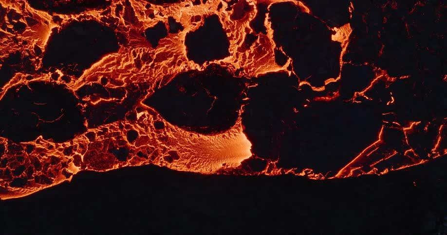 An intense aerial top-down view of a glowing lava river flowing and solidifying into black rock