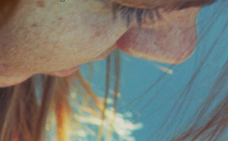A dreamy and vintage extreme close-up of a woman's closed eye with a double exposure of glowing light trails