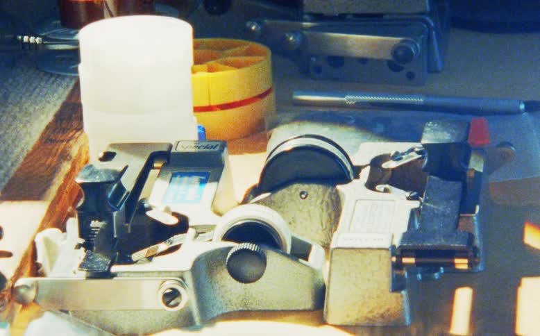 Time-lapse shot of light moving across a vintage film splicer and other editing tools on a desk