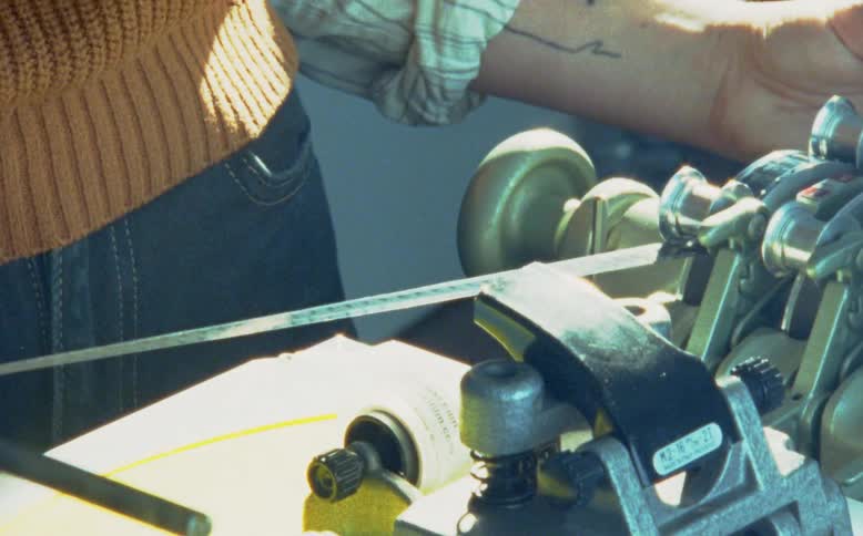 Close up of a film strip running through a vintage film editing synchronizer in a post-production studio