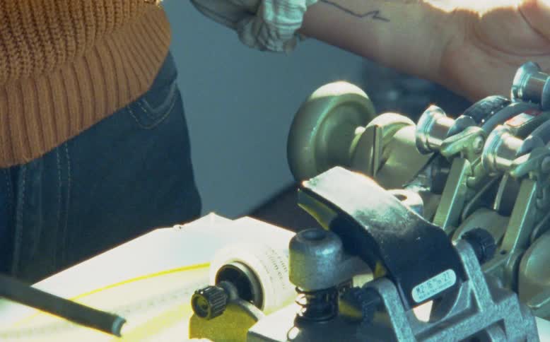 Close up of a 16mm or 35mm film strip being wound through a vintage flatbed film editor