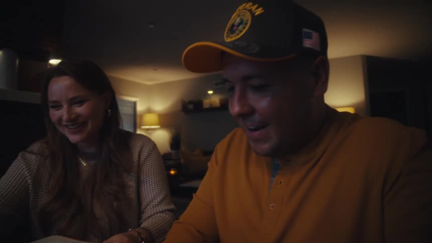 A cheerful couple collaborates on their finances late at night in their cozy home, smiling at the results
