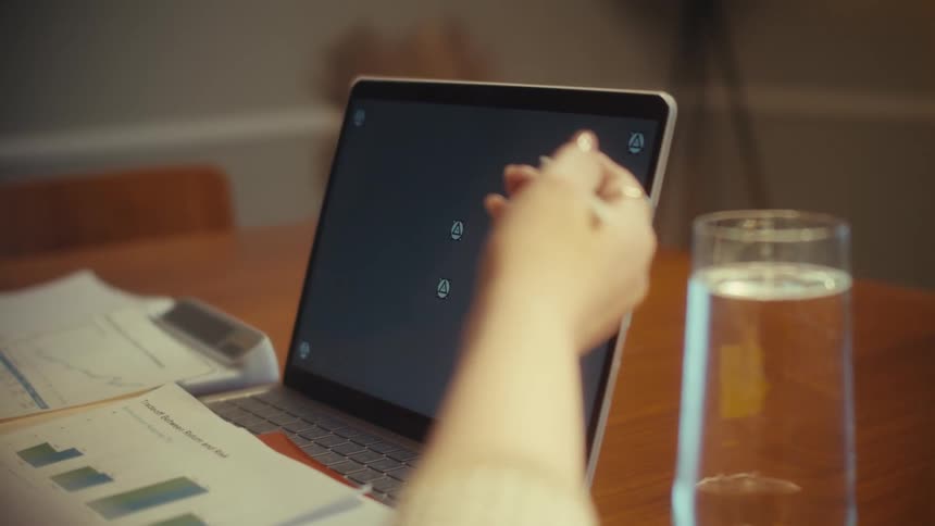 An over-the-shoulder shot of a person using a stylus on a laptop with tracking markers for screen replacement