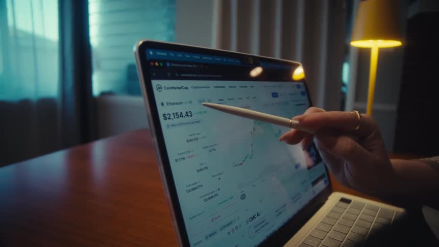A team of financial analysts review investment portfolio growth charts on paper and track live cryptocurrency data on a laptop