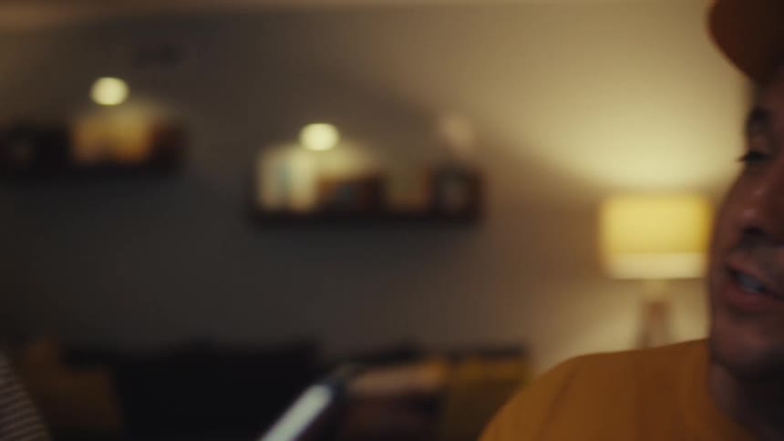 A man and a woman have a pleasant and engaging conversation in a warmly lit, cozy living room at night