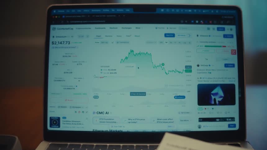 A person points at a volatile cryptocurrency price chart on a laptop screen, analyzing the market trends