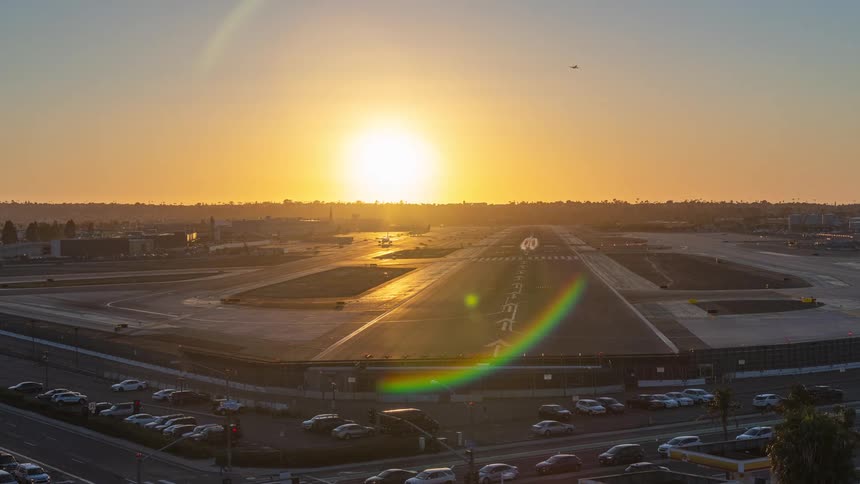 Stunning timelapse of airplanes landing and taking off from a busy airport runway as the sun sets in a golden sky