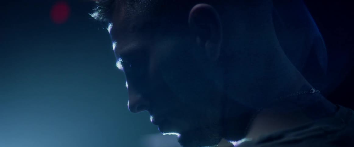 A man standing in a dark room with bright flashing lights