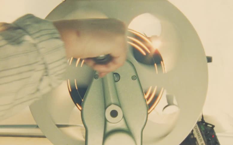 Dreamy double exposure shot of a hand manually cranking a vintage film editing machine