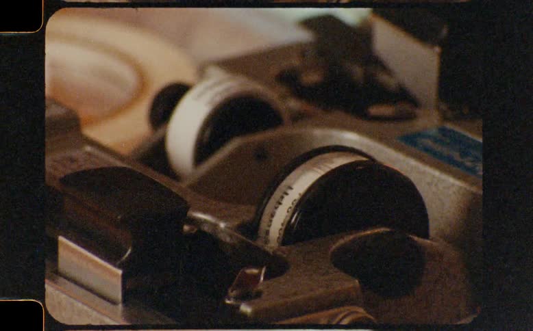 Close up shot of a retro film editor's splicer in operation, captured on authentic vintage 8mm film