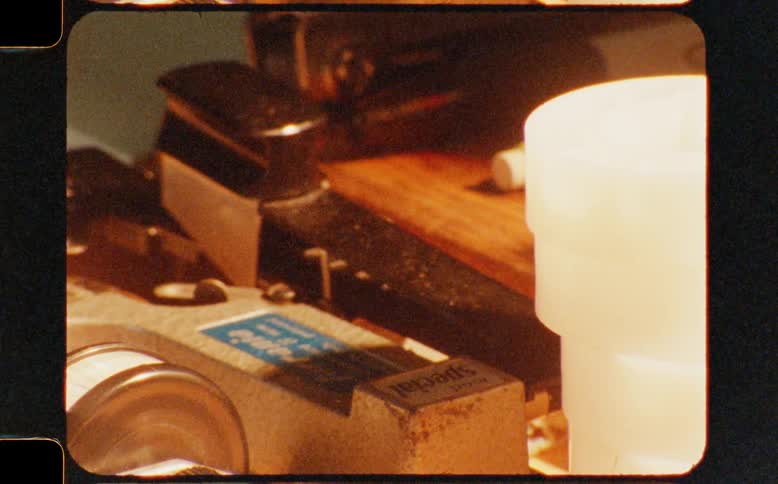 A close-up shot of vintage film editing equipment on a workbench, captured on authentic super 8mm film
