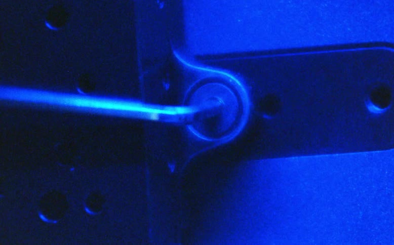 A close-up shot of a hex key tightening a bolt under dramatic, multi-colored flashing lights