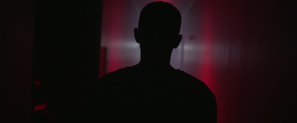 Man walks down a dark hallway
