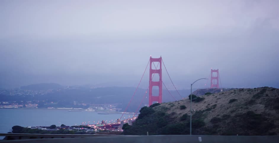 Point of view shot driving out of a dark tunnel to reveal the iconic Golden Gate Bridge on a foggy evening in San Francisco