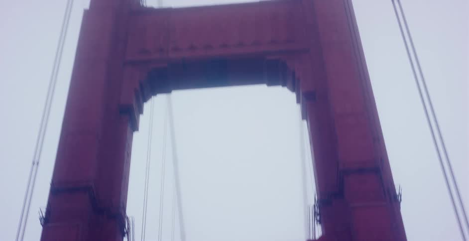 A point-of-view shot driving across the iconic Golden Gate Bridge in San Francisco as the towers disappear into the thick fog