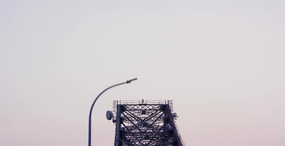 A slow, detailed pan down the complex steel architecture of the Howrah Bridge in Kolkata at twilight