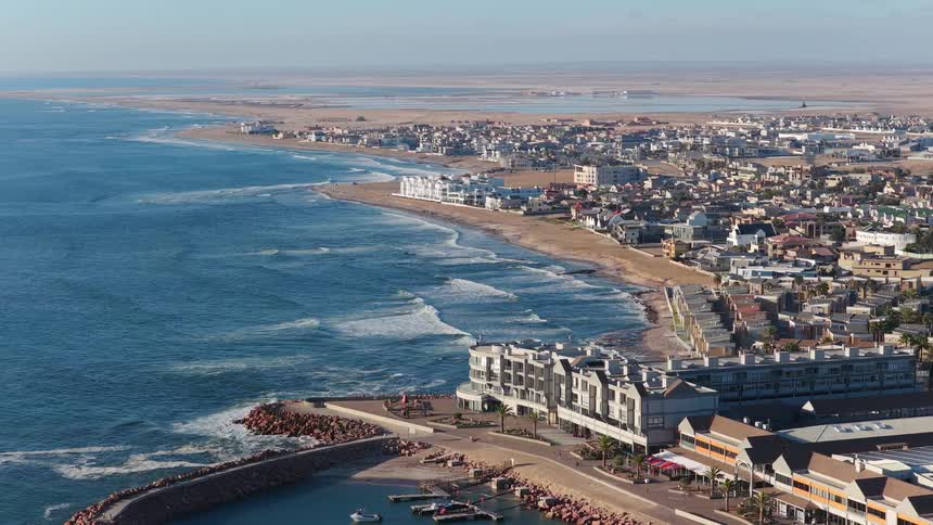 A static aerial view shows the coastal city of Swakopmund in Namibia, where the desert meets the Atlantic Ocean