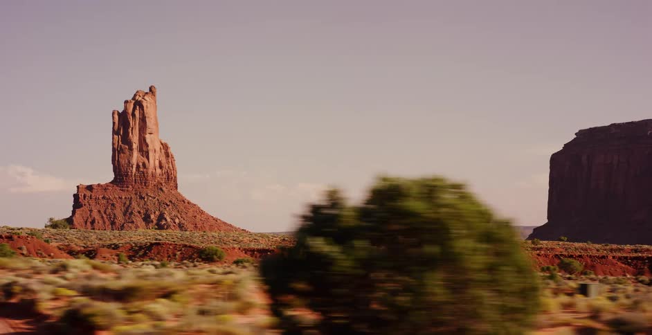 Driving past the majestic red rock buttes of Monument Valley on a sunny day in the American West