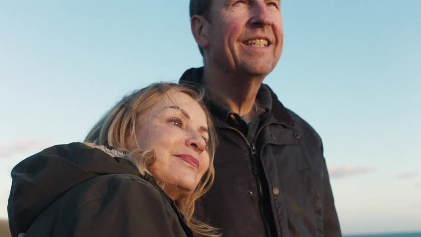 A close-up shot of a loving senior couple enjoying a beautiful view together during golden hour
