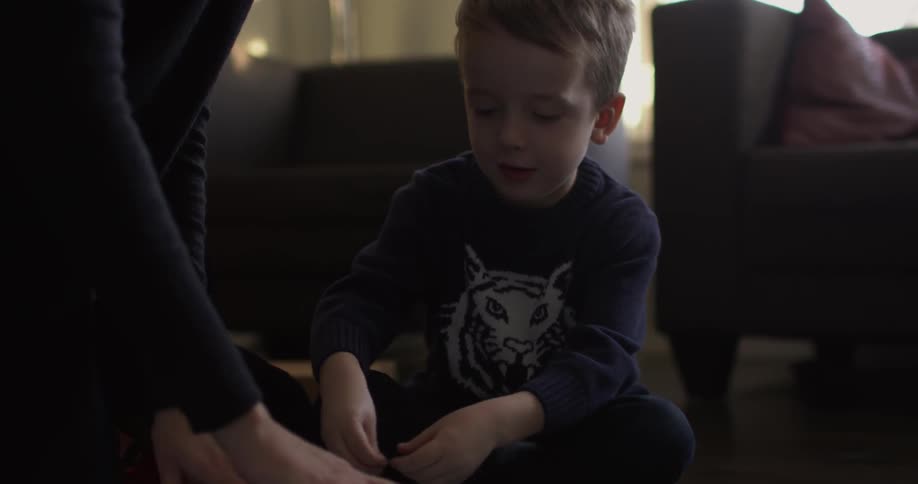 A little boy helps wrap presents