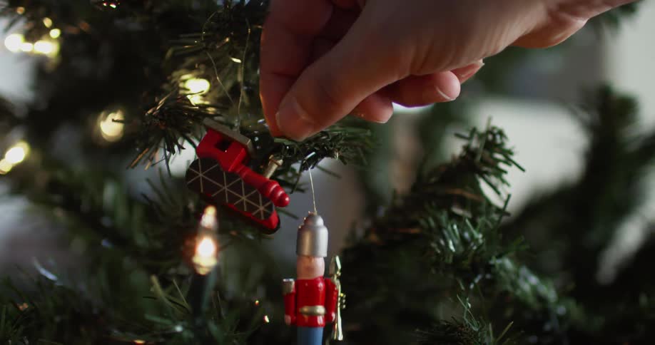 A person hanging a nutcracker ornament