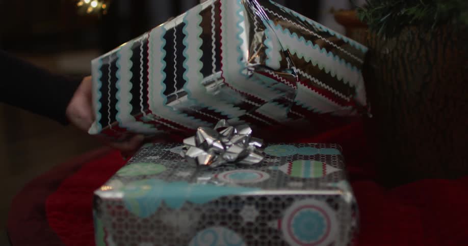 Christmas gifts are placed beneath a tree