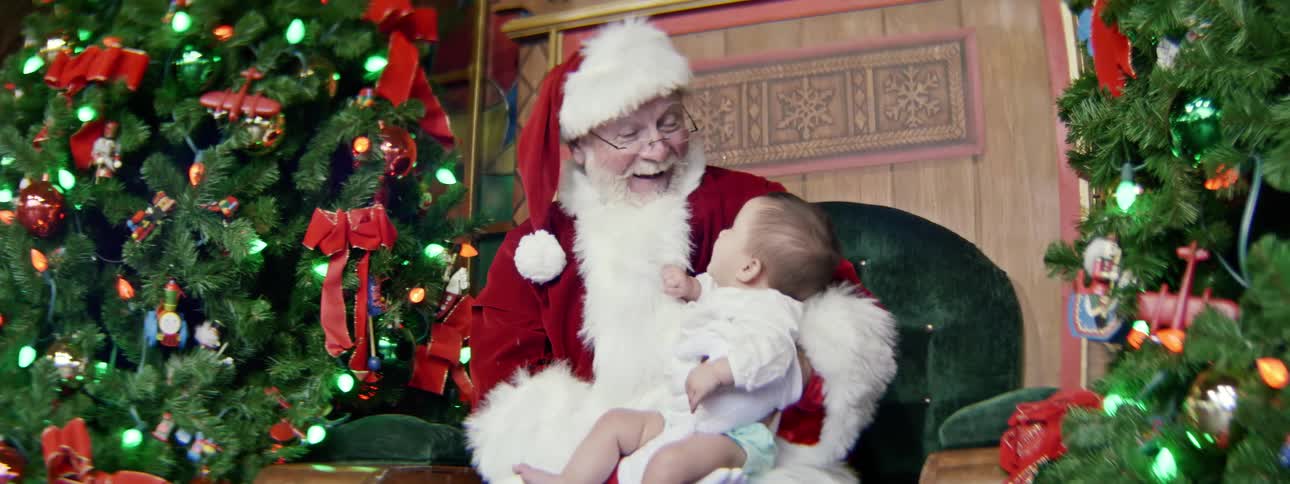 Santa clause holds a baby