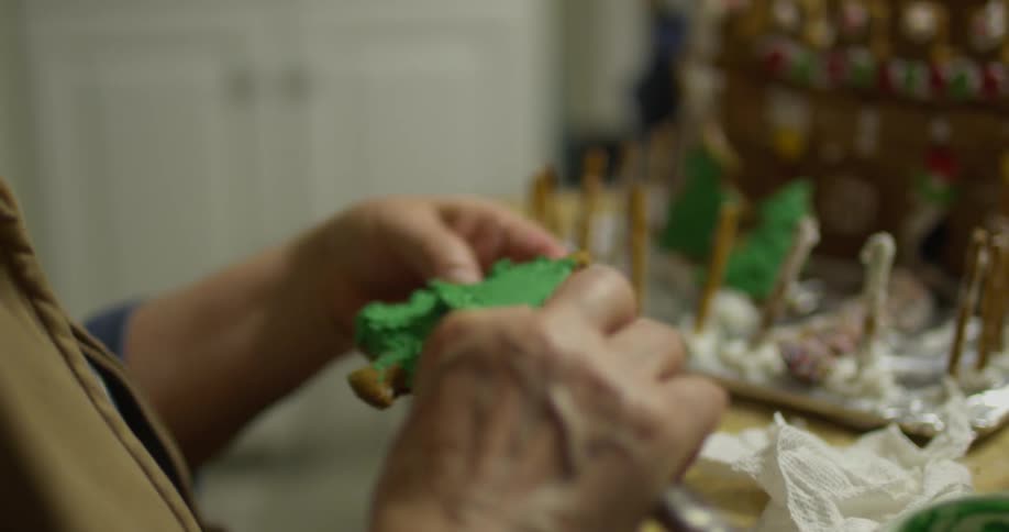 Someone is spreading frosting on a gingerbread tree