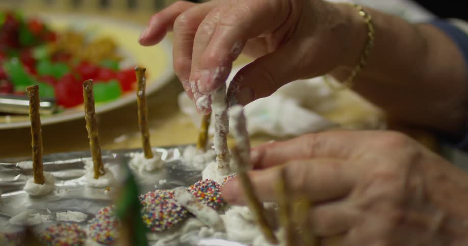 A person adjusts pretzels on a food sculpture