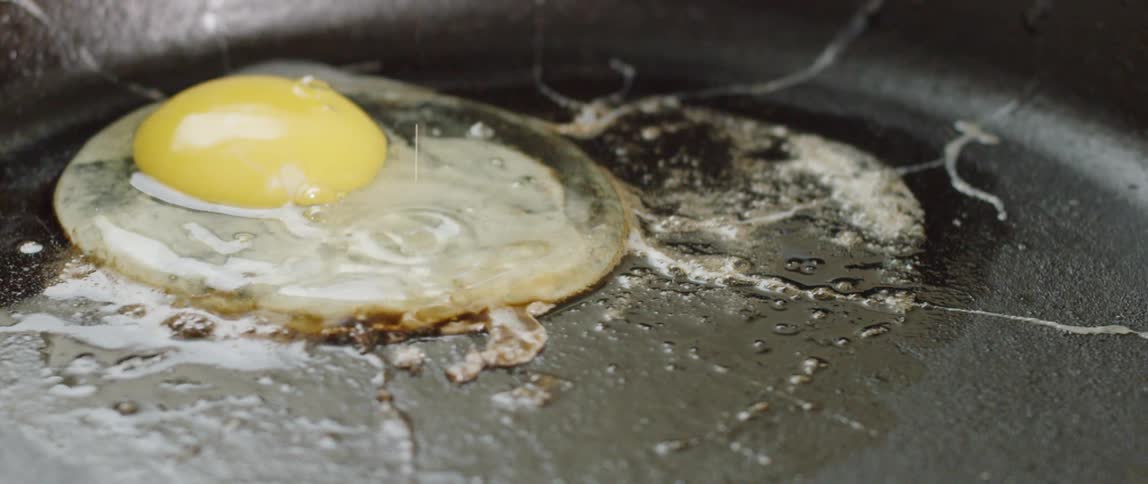 An egg drops in the pan to cook