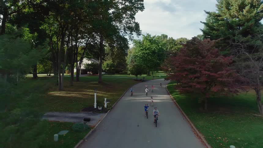 A group of children are riding their bikes in a suburban area