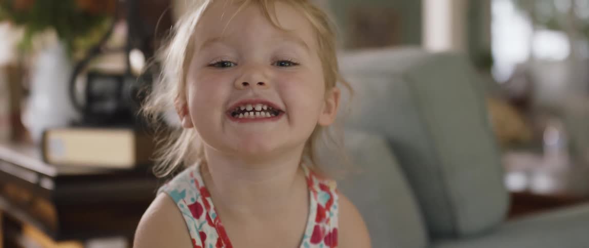 A young girl smiles inside a home