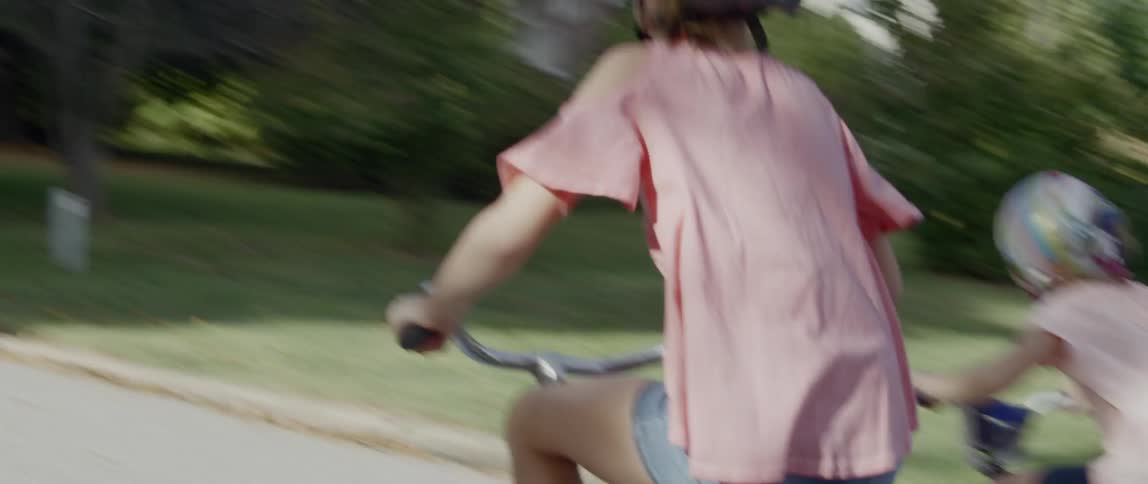 A group of children are riding their bikes in a suburban area
