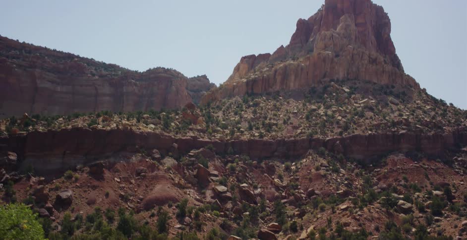 A slow zoom reveals the majestic red rock mountains and canyons of a desert landscape