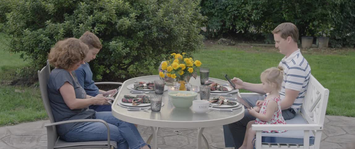A family dines at an outdoor patio table