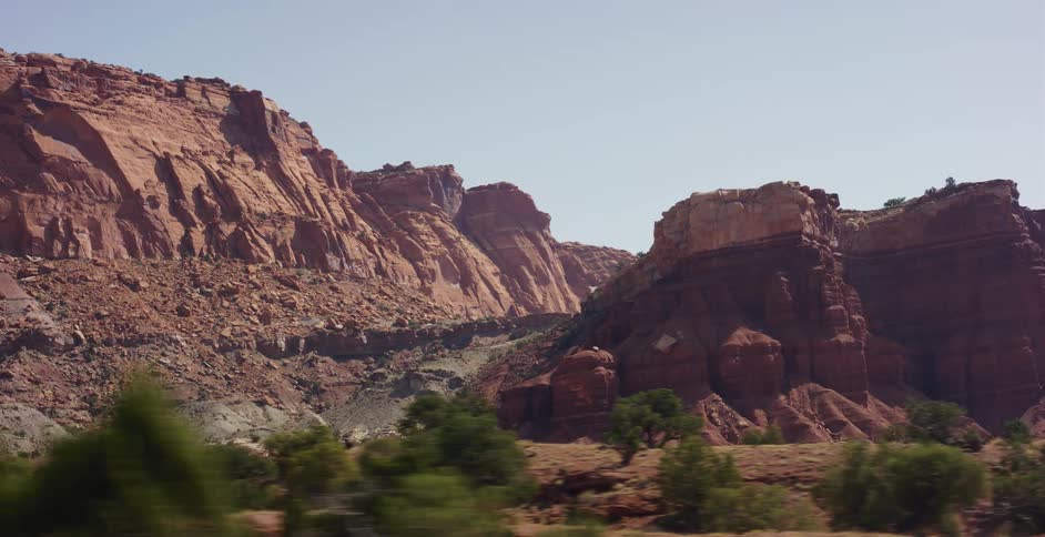 Driving through the breathtaking landscape of a sun-drenched red rock canyon in the American Southwest