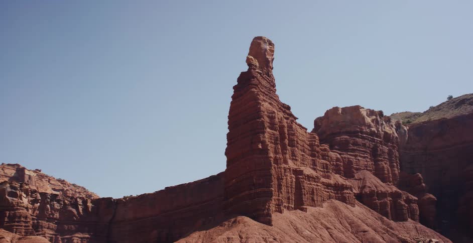 A slow, smooth tracking shot reveals the towering Chimney Rock in Capitol Reef National Park, Utah