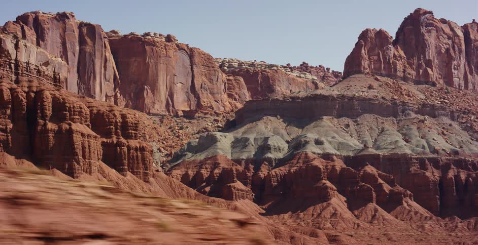 Cinematic pull-back reveals the vast and colorful layered cliffs of Capitol Reef National Park in Utah