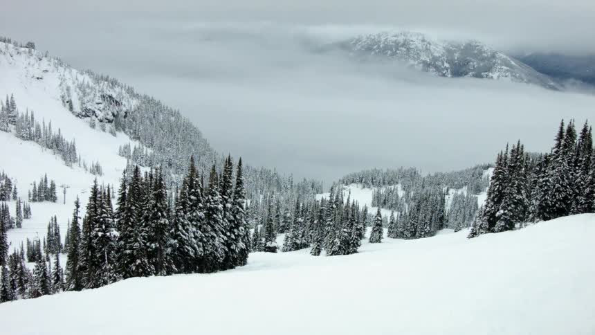 Fog surrounds snow covered mountains