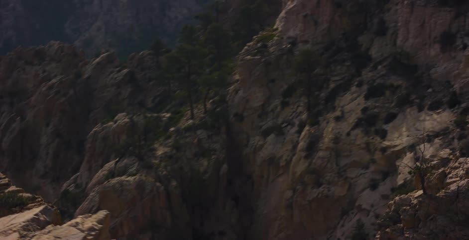 A breathtaking slow pan reveals the immense and rugged beauty of a sunlit rocky canyon