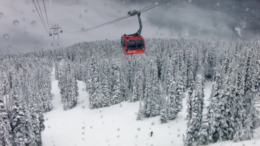 Enclosed ski lifts go up and down the mountainside