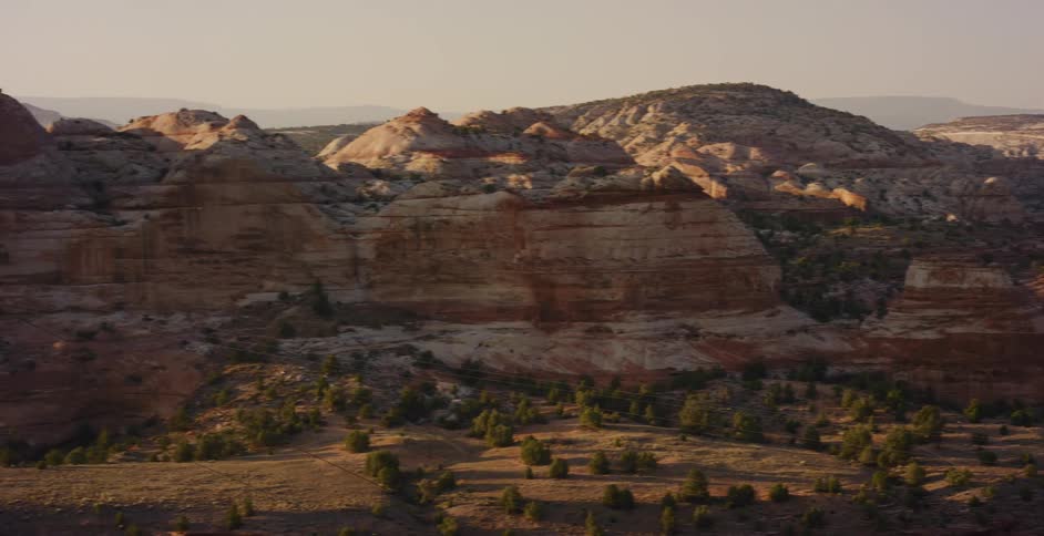 A slow pan across a stunning desert canyon reveals its intricate rock formations bathed in the warm light of sunrise
