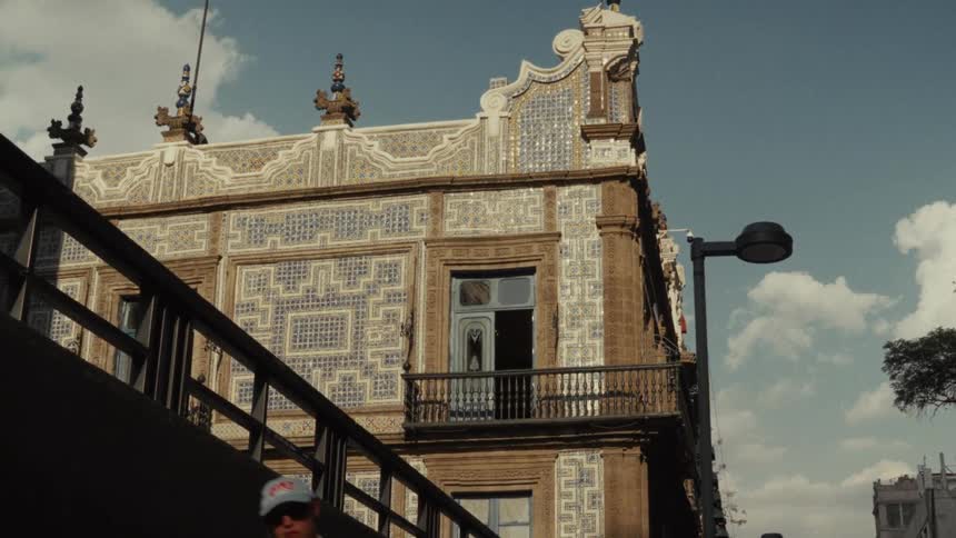 A man walks by the historic Casa de los Azulejos building in Mexico City as clouds pass by in a time-lapse