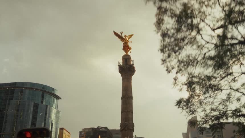 A slow push-in reveals the iconic Angel of Independence monument against a moody, overcast sky in Mexico City