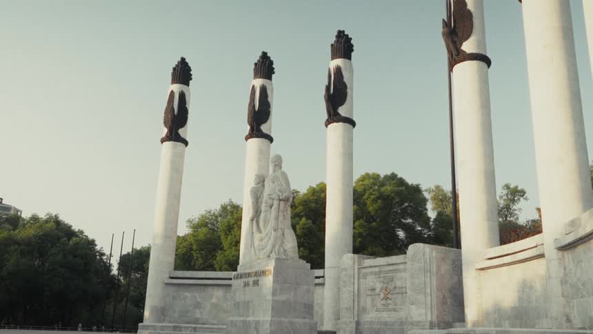 The impressive marble columns of the Monumento a los Niños Héroes stand tall against a clear sky in Mexico City